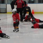 youth hockey kids laying on the ice