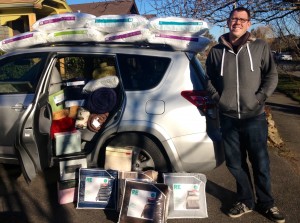 Pass The Hat founder Galen Emanuele is all smiles as he delivers new bedding to a local family who lost their home in a fire. Photo courtesy: Galen Emanuele.