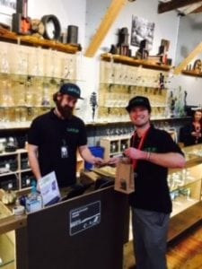 Owner Quinn Sharp made the first ceremonial purchase at Satori from General Manager, Joshua Besecker. Photo courtesy: Satori Cannabis Boutique.
