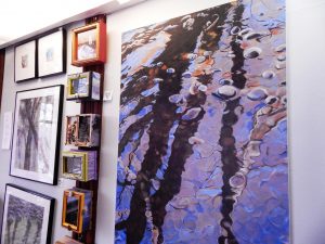 Nancy Canyon paints reflections of trees in the water of Padden Creek. This painting appears on the cover of her book, Dark Forest. Photo credit: Patricia Herlevi.