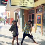 Wild Buffalo – Cedric Walker – Eva Walker and friend Miles smiling at the Wild Buffalo sign
