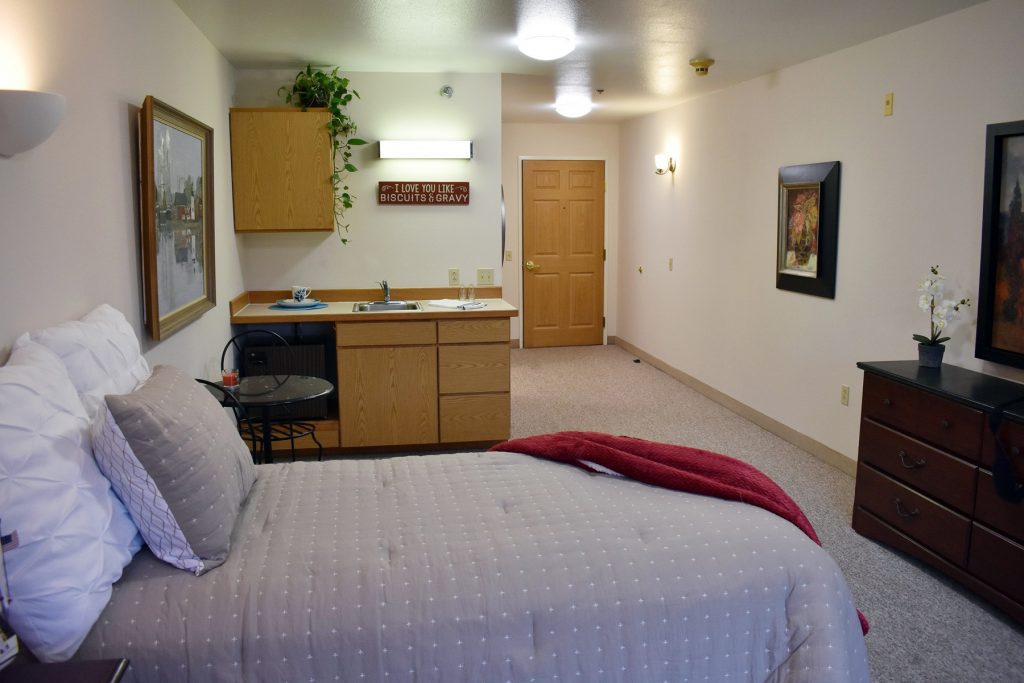 assisted living space with bed and small kitchen area