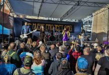 a band performs on an outdoor stage to a large crowd at the Come As You Are Music Festival